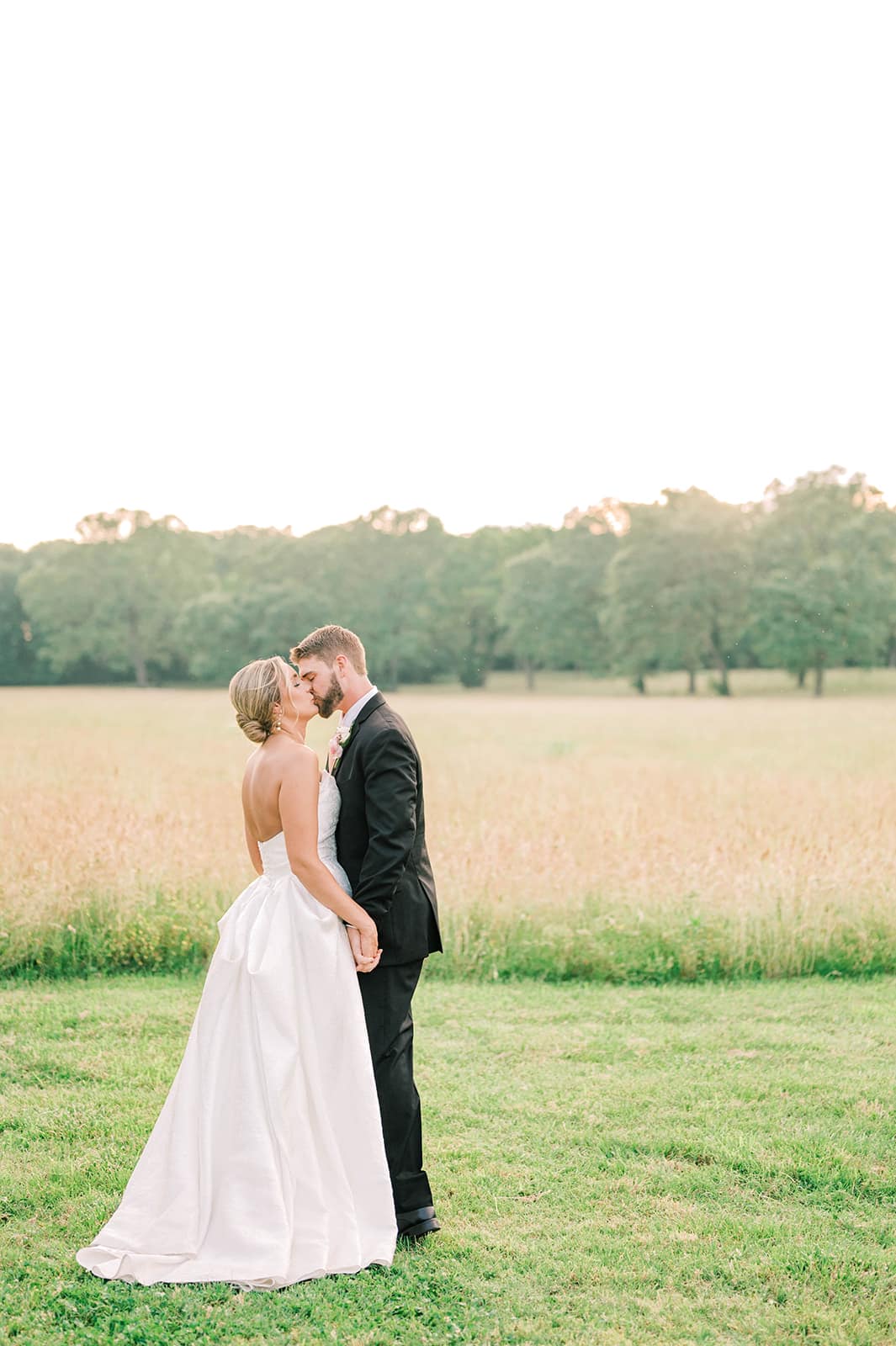 449467072_1000952298704037_2313606573018025088_n bride and groom kissing in green field