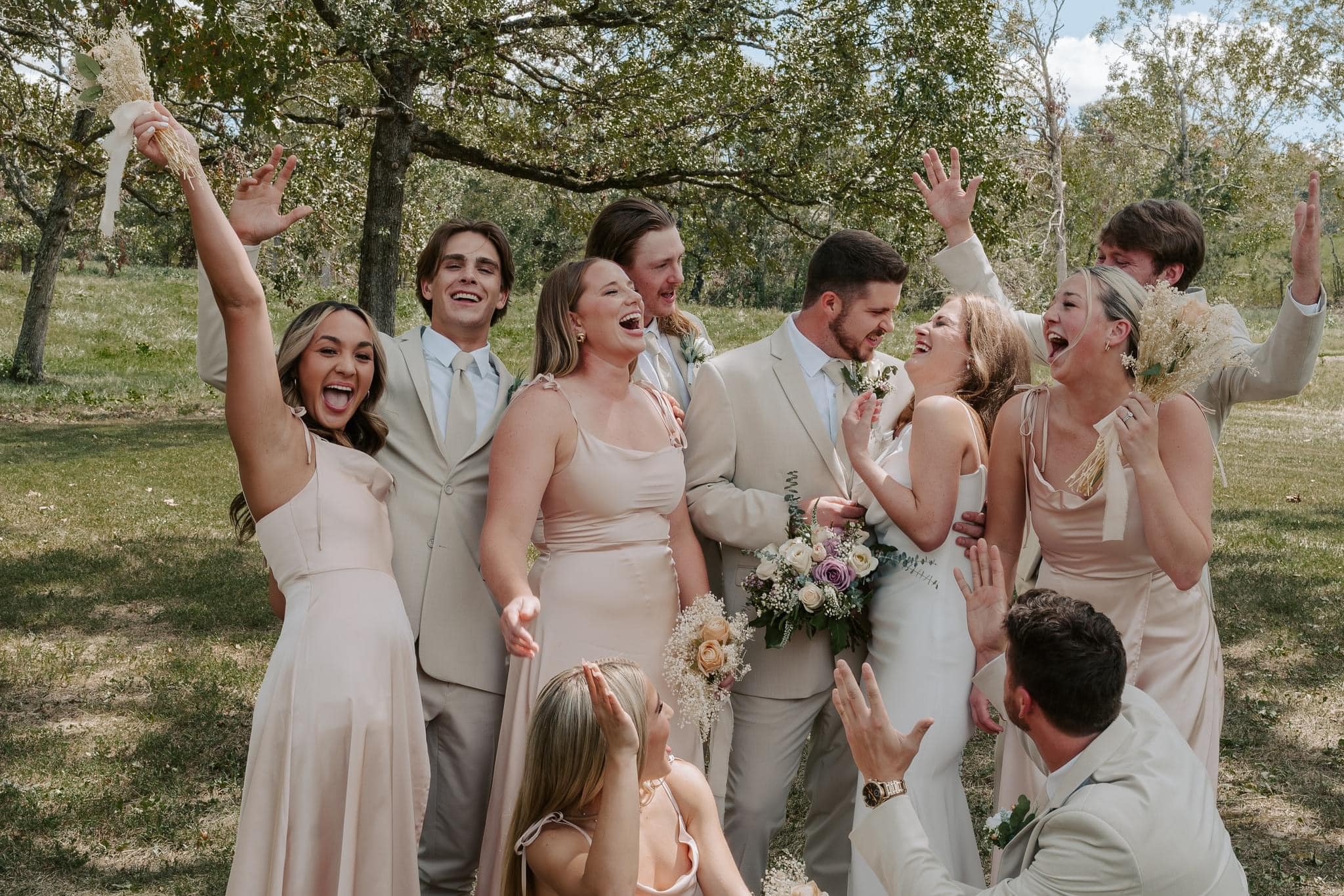 469247905_1122836903182242_3351116463211965061_n bride and groom laughing with wedding party